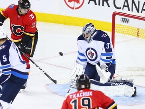 Winnipeg Jets goaltender Connor Hellebuyck stopped this Calgary Flames shot during NHL at the Scotiabank Saddleome in Calgary in 2018 with Flames forward Matthew Tkachuk on his doorstep. The two will probably see alot of each other in the qualifying series.