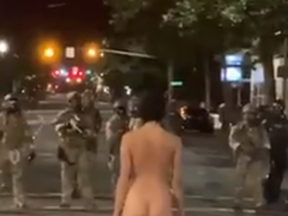 'Naked Athena' faces off with police during a Portland protest on Friday, July 17, 2020.