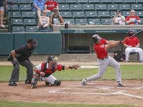 Winnipeg’s Eric Wood swings and misses while Fargo-Moorhead’s Dylan Kelly catches the ball yesterday.  (Alyssa Goelzer / The Forum)