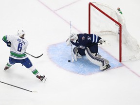 Connor Hellebuyck #37 of the Winnipeg Jets makes a save against Brock Boeser #6 of the Vancouver Canucks during the second period in an exhibition game prior to the 2020 NHL Stanley Cup Playoffs at Rogers Place on Wednesday.