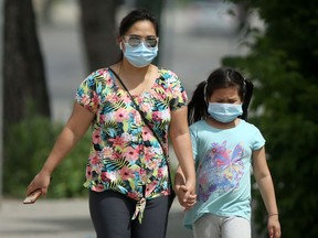 Two people walk along Salter Street while wearing masks, in Winnipeg on Wednesday, July 1, 2020. Chris Procaylo/Winnipeg Sun