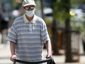 A person wears a mask while walking along Broadway.