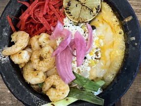 The signature dish of the Junction 59 Roadhouse in Winnipeg is the Molcajete Bowl. It's basically fajitas but the onions, peppers, cheese, beans, corn, rice and red sauce is all served up in a red-hot stone bowl.
