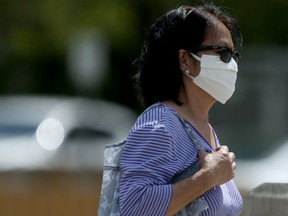 A woman wears a face mask while walking along Portage Avenue on Friday.