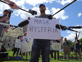 Patrick Allard of Manitoba Together speaks to media during a March to Unmask event in front of the Manitoba Legislative Building on Sunday, July 19, 2020.