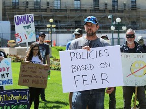 Patrick Allard of Manitoba Together speaks during a March to Unmask event in front of the Manitoba Legislative Building on Sunday.
