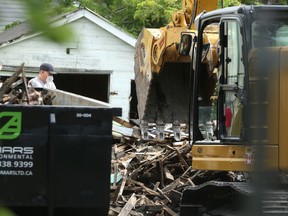 Investigators look through debris at a fire scene on Alfred Avenue, in Winnipeg, for clues in the death of a man whose body was dumped in Portage La Prairie. Wednesday, July 22/2020.