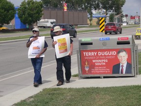 Two protesters take part in a protest in front of Winnipeg South MP Terry Duguid's office on Pembina Highway in Winnipeg on Friday as part of a National Day of Action “Strike for Climate Peace: No New Fighter Jets” to oppose the Canadian government’s plan to spend $19 billion for 88 new fighter jets.