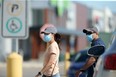 People walking through a parking lot, wearing masks, in Winnipeg. Tuesday, July 28/2020.