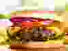 hamburger with fries on wooden table