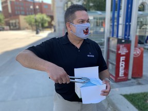 Winnipeg City Councilor Jeff Browaty hands out facemasks to transit riders next to City Hall on Monday afternoon. James Snell/Postmedia