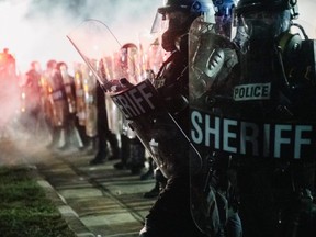 Law enforcement hold a line in Kenosha, Wisconsin, Tuesday, Aug. 25, 2020, during a third night of civil unrest following the shooting of Jacob Blake, 29, on Aug. 23.