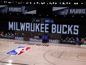 Referees huddle on an empty court at game time of a scheduled game between the Bucks and Magic for Game 5 of the Eastern Conference First Round during the 2020 NBA Playoffs at AdventHealth Arena at ESPN Wide World Of Sports Complex in Lake Buena Vista, Fla., Wednesday, Aug. 26, 2020.