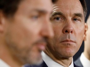 Minister of Finance, Bill Morneau, looks at Prime Minister Justin Trudeau during a press conference in Ottawa March 11, 2020.