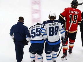 Jets forward Mark Scheifele is helped off of the ice by Nathan Beaulieu after a hard hit against the Calgary Flames in Game One of their playoff series last night.