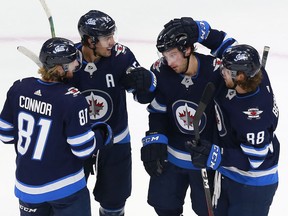 Tucker Poolman (3) of the Winnipeg Jets celebrates with teammates after scoring a goal during the first period against the Vancouver Canucks in an exhibition game prior to the 2020 NHL Stanley Cup Playoffs at Rogers Place on July 29, 2020 in Edmonton.