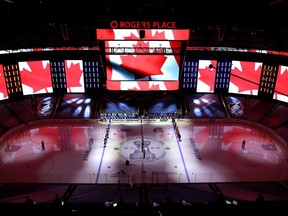The Winnipeg Jets and the Calgary Flames stand on the ice for the Canadian national anthem before Game Two of the Western Conference Qualification Round prior to the 2020 NHL Stanley Cup Playoffs at Rogers Place on August 3, 2020 in Edmonton, Alberta.
