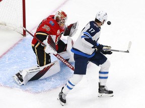 Adam Lowry of the Winnipeg Jets gets the puck past Cam Talbot of the Calgary Flames in the second period to score during Game Two of the Western Conference Qualification Round prior to the 2020 NHL Stanley Cup Playoffs at Rogers Place on August 3, 2020 in Edmonton, Alberta.