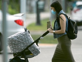 People walking through a parking lot, wearing masks, in Winnipeg.