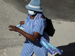 A person walks across a street, while wearing a mask, in Winnipeg.   Thursday, August 06/2020.Winnipeg Sun/Chris Procaylo/stf