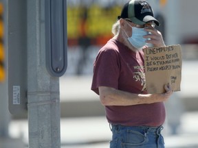 A man wears a surgical mask while begging in a roadway, in Winnipeg on Tuesday, August 11, 2020.
Chris Procaylo/Winnipeg Sun