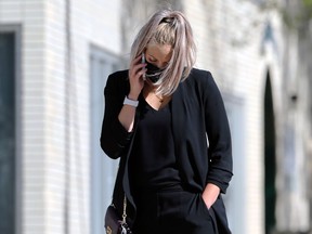 A woman wearing a mask speaks on her cellphone along Sherbrook Street in Winnipeg on Mon., Aug. 10, 2020. Kevin King/Winnipeg Sun/Postmedia Network