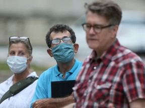 Manitoba Liberal Leader Dougald Lamont (right) talks about safety concerns over a a mine project that is intended to produce sand that will be mostly be used for fracking.  Tango Bell (left), and Dennis LeNeveu wear masks while listening.  Thursday, August 13/2020.Winnipeg Sun/Chris Procaylo/stf