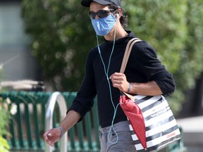 A person walks along Ellice  Avenue, in Winnipeg, while wearing a surgical mask. Friday, August 21, 2020. Chris Procaylo/Winnipeg Sun