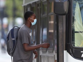 A person wears a mask while boarding a transit bus, in Winnipeg.   Friday, August 28/2020.Winnipeg Sun/Chris Procaylo/stf