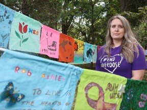 Rebecca Rummery, co-founder of Overdose Awareness Manitoba, stands among flags of hope while advocating for an unscheduling of naloxone, which can reverse the affects of an opioid overdose, during an International Overdose Awareness Day gathering at Stephen Juba Park in Winnipeg on Monday.