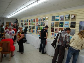 Patrons examine the artworks at the annual Square Foot exhibition and auction at the NorVA Northern Visual Arts Centre in Flin Flon, Man. The Square Foot exhibition and auction gives an opportunity to those who are interested to get involved in the arts, regardless of their skill level. All of the artworks will be presented in the exhibition and later auctioned to interested buyers.
