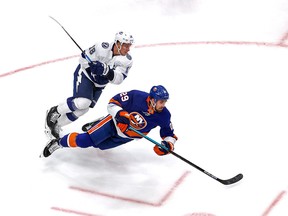 Brock Nelson of the New York Islanders gets tripped up by Ondrej Palat of the Tampa Bay Lightning during Game 4 on Sunday in Edmontron