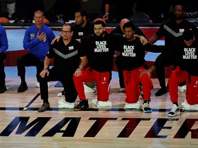 Toronto Raptors head coach Nick Nurse (left), guard Fred VanVleet (23) and guard Kyle Lowry (7) kneel during the national anthem prior to Game three of the second round of the 2020 NBA Playoffs against the Boston Celtics.