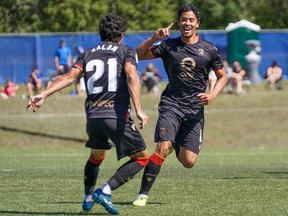 Valour FC midfielder Moses Dyer celebrates his first-half goal with teammate Jose Galan in action against Forge FC at the Canadian Premier League Island Games tournament in Charlottetown, P.E.I., on Saturday. The game ended in a 2-2 draw.