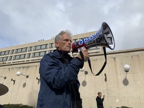 Retired chiropractor Gerry Bohemier showed up at City Hall on Wednesday to protest against mandatory mask wearing and COVID-19 restrictions. James Snell/Postmedia