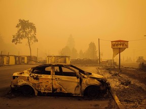 A charred vehicle is seen in the parking lot of the burned Oak Park Motel after the passage of the Santiam Fire in Gates, Oregon, on Sept. 10, 2020.