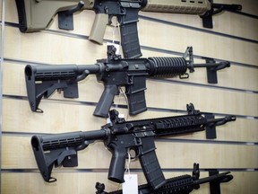 Assault rifles are displayed on a wall.