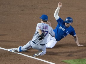 New York Mets pitcher Seth Lugo (67) gets a force out by beating Toronto Blue Jays third baseman Travis Shaw (6) to third base during the fourth inning at Sahlen Field.