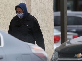 A person wears a mask while walking near Salter Street, in Winnipeg.