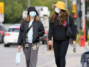 People wearing masks walk on Osborne Street in Winnipeg on Monday, Sept. 7, 2020.