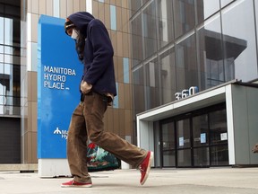A man walks past Manitoba Hydro Place on Portage Avenue in Winnipeg on Thurs., Sept. 17, 2020. Kevin King/Winnipeg Sun/Postmedia Network
