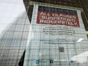 A sign on the entrance doors to the Munroe Early Childhood Education Centre on Chalmers Avenue in Winnipeg is pictured on Sunday. The entrance is next to the high school doors.