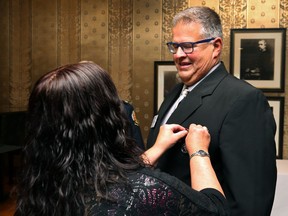 Gabriel (Dancing Gabe) Langlois has his Sovereign's Medal for Volunteers pinned on him by sister Claudette during a ceremony at Government House in Winnipeg on Monday.