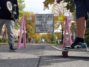 Students pass a road sign for the School Street project at Isaac Brock School in Winnipeg on Thursday.