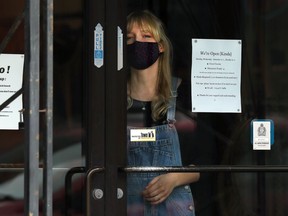 An employee at Osborne Village clothing store Out of the Blue manages the door to keep the number of shoppers within COVID-19 guidelines in Winnipeg on Thursday, Sept. 24, 2020.