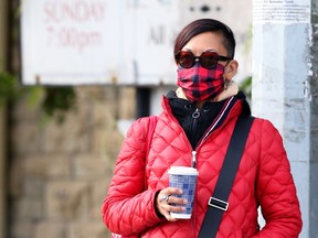 A woman waits for a bus on Osborne Street in Winnipeg on Tuesday, Sept. 29, 2020.