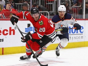 Brandon Saad of the Chicago Blackhawks looks to pass under pressure from Ethan Bear of the Edmonton Oilers at the United Center on March 05, 2020 in Chicago, Illinois.