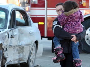 Paramedic Jennifer Setlack carries a child to an ambulance following a two vehicle collision at Ellice and Maryland in Winnipeg Jan. 2, 2011. Collision occurred approximately 2:30 p.m.