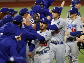 Los Angeles Dodgers right fielder Mookie Betts (50) and the rest of the Dodgers celebrate their 7-3 win over the Atlanta Braves in Game five of the 2020 NLCS at Globe Life Field in Arlington, Texas.