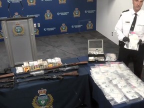 Winnipeg Police Insp. Max Waddell holds a package of Fentanyl as he speaks during a media briefing at the WPS headquarters on Friday on drug raids that occurred on June 22 at two residences in Winnipeg where a large quantity of Fentanyl pebbles were seized along with weapons, jewelry and cash. Three men face drug trafficking charges. Image was taken off Facebook live broadcast.